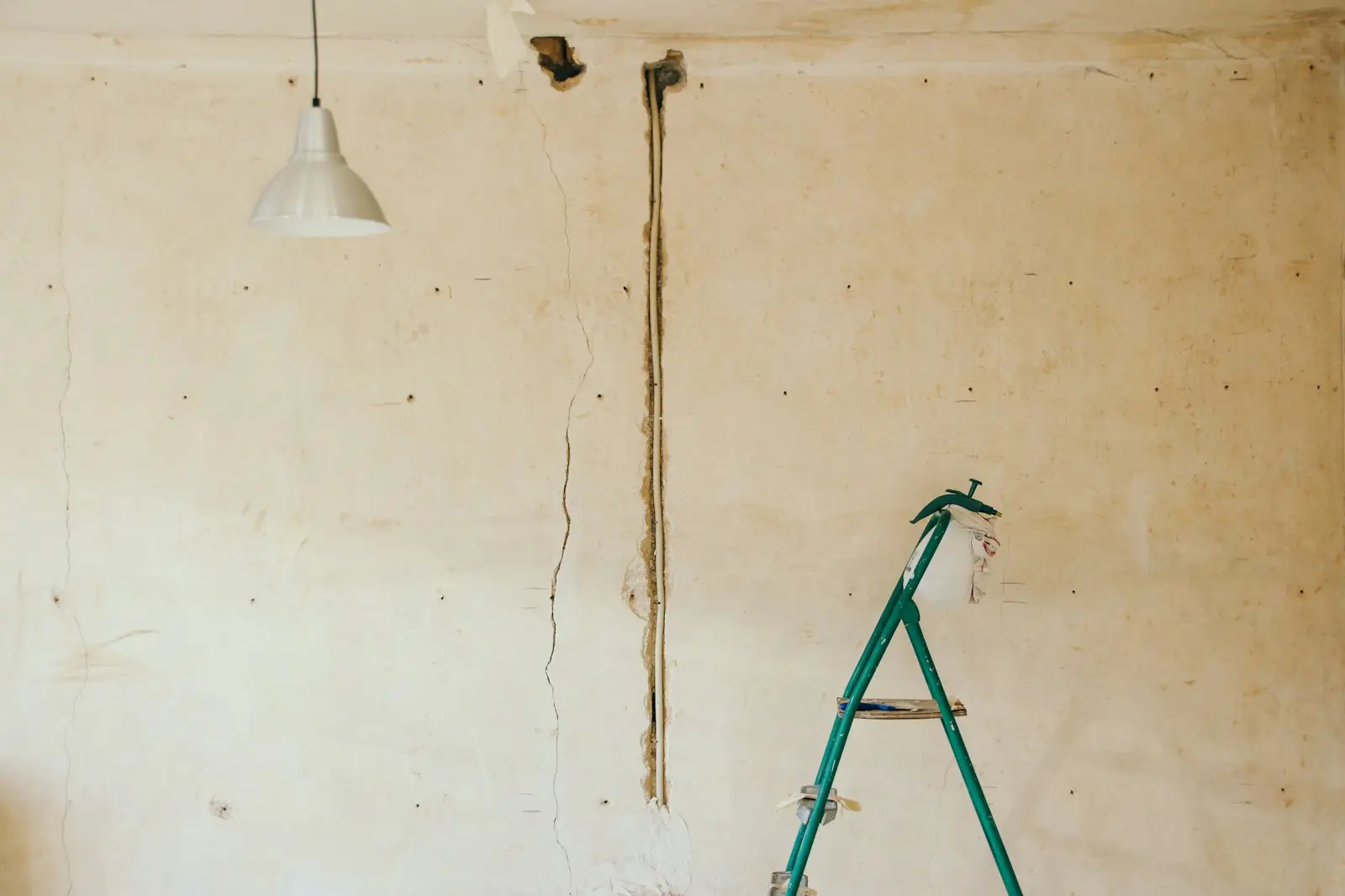 A stripped-back room mid-renovation with a single bulb hanging from the ceiling